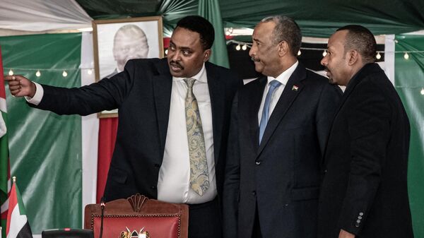 Executive Secretary of the Inter-Governmental Authority on Development (IGAD) and Ethiopia's Former Minister of Foreign Affairs Workneh Gebeyahu (L) gestures next to Sudan's President of the Transitional Sovereignty Council Abdel Fattah al-Burhan (C) and Ethiopia President Abiy Ahmed (R) during the 39th IGAD extraordinary summit in Nairobi on July 5, 2022. - Sputnik International