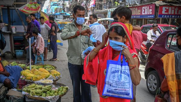 Health workers distribute face masks as a safety protocol to curb the spread of Covid-19 coronavirus in Kolkata on July 4, 2022 - Sputnik International