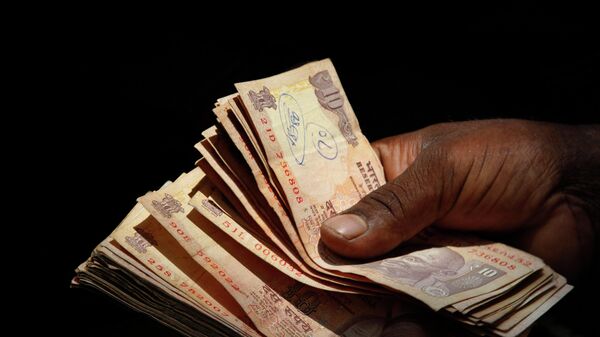 An Indian vendor counts 10 rupee notes at a shop in Hyderabad, India, Sunday, Sept. 1, 2013. - Sputnik International