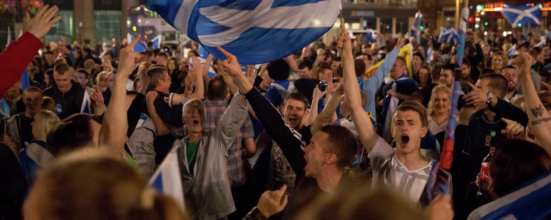 Supporters of the Yes campaign in the Scottish independence referendum wave Scottish Saltire flags as they await the result after the polls closed, in Glasgow, Scotland. - Sputnik International, 1920, 07.07.2022