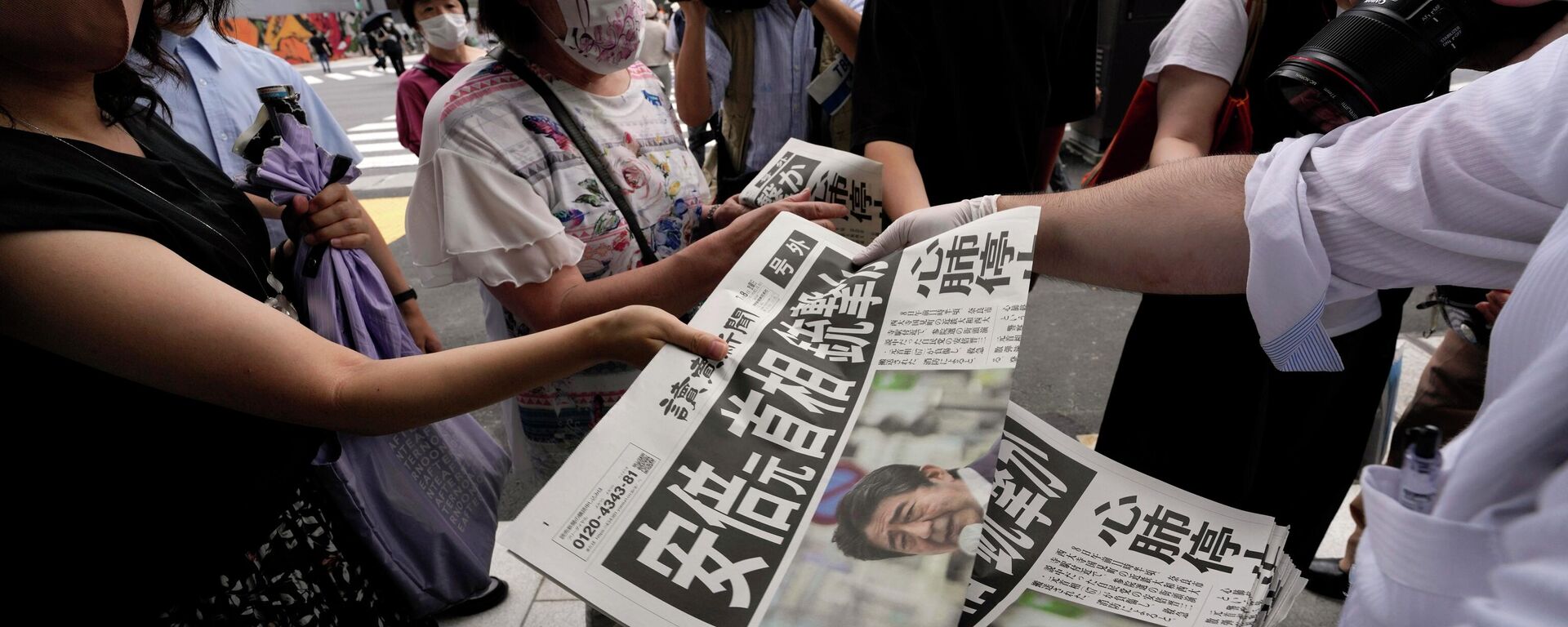 An employee distributes extra editions of the Yomiuri Shimbun newspaper reporting on Japan's former Prime Minister Shinzo Abe was shot, Friday, July 8, 2022, in Tokyo. Japan's former Prime Minister Shinzo Abe was shot during a campaign speech Friday in western Japan and was airlifted to a nearby hospital but he was not breathing and his heart had stopped, officials said.  - Sputnik International, 1920, 10.07.2022