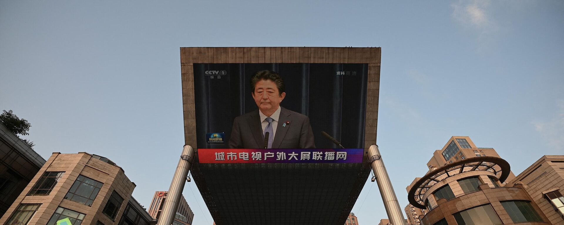 A large video screen shows news broadcast featuring an image of former Japanese prime minister Shinzo Abe in Beijing on July 8, 2022. - Sputnik International, 1920, 08.07.2022