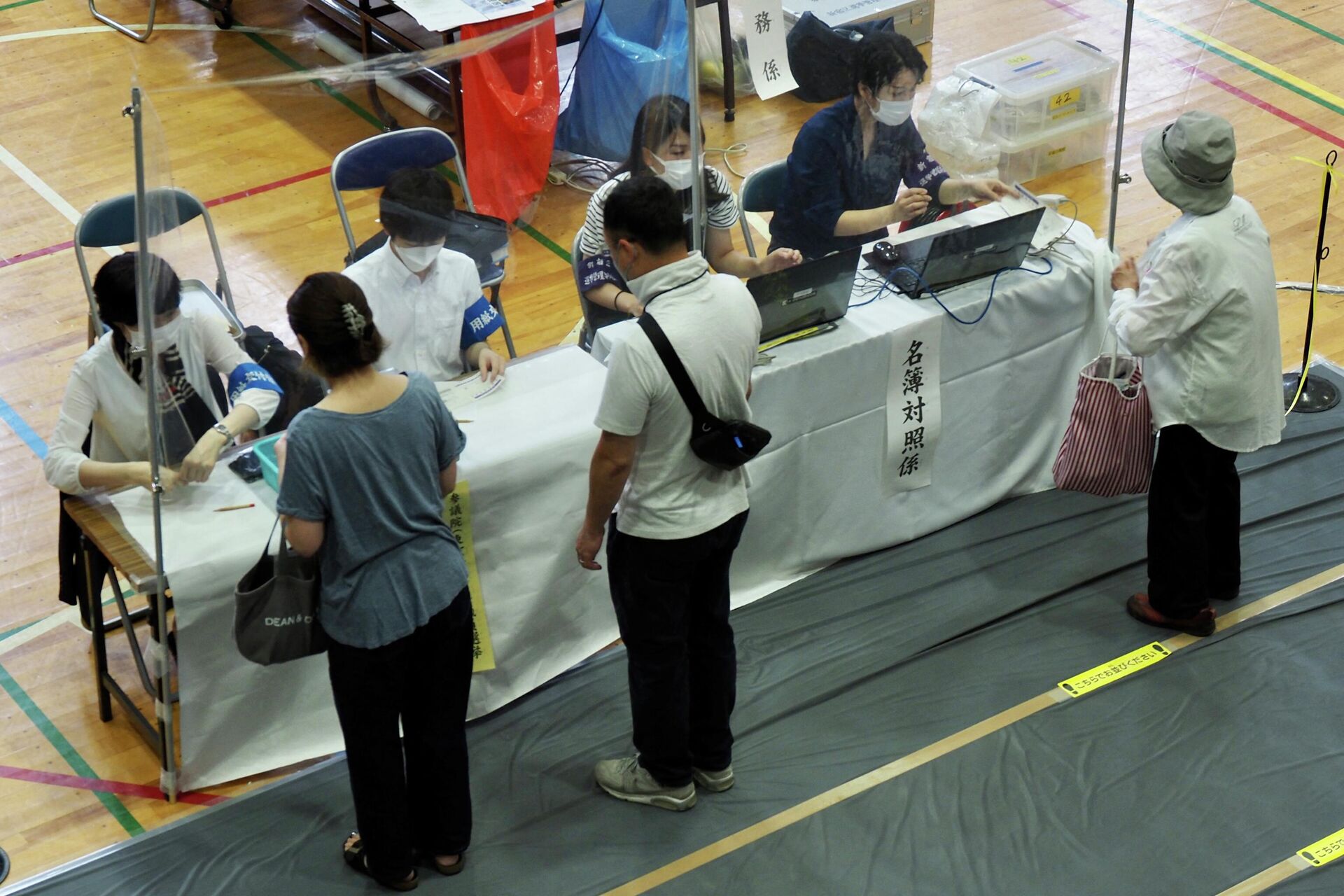 Voters receive their ballots during Japan's upper house election at a polling station in Tokyo on July 10, 2022. - Polls opened on July 10 in Japan's upper house elections, just two days after former prime minister Shinzo Abe was assassinated while on the campaign trail. - Sputnik International, 1920, 10.07.2022