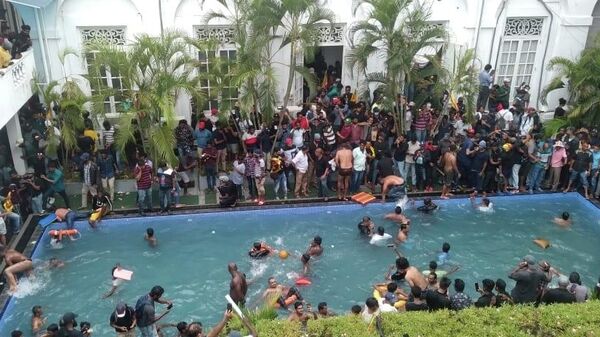 Anti government protesters swim in a pool at the president's official residence after storming into it in Colombo, Sri Lanka, Saturday July 9, 2022.  - Sputnik International
