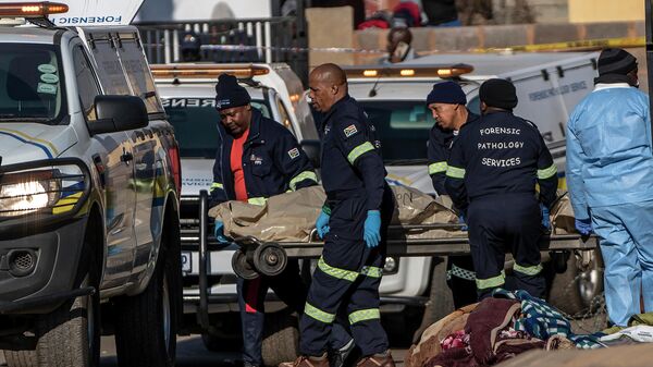 A body is removed from the scene of an overnight bar shooting in Soweto, South Africa, Sunday July 10, 2022. A mass shooting at a tavern in Johannesburg's Soweto township has killed 15 people and left others in critical condition, according to police. Police say they are investigating reports that a group of men arrived in a minibus taxi and opened fire on some of the patrons at the bar shortly after midnight Sunday. - Sputnik International