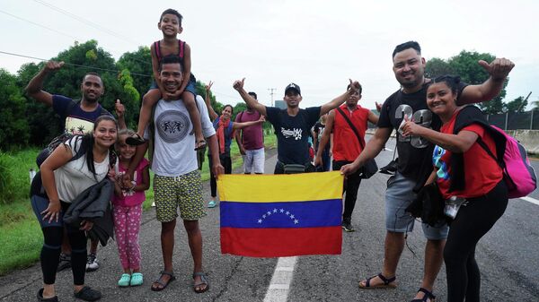 Migrants, many from Central American and Venezuela, stop to pose for a photo as they walk along the Huehuetan highway in Chiapas state, Mexico, early Tuesday, June 7, 2022. - Sputnik International