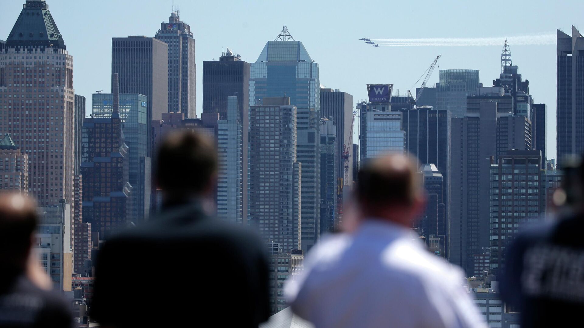 People watch as a formation of the Blue Angels and Thunderbirds flight teams pass in front of the New York City skyline as seen from Weehawken, N.J., Tuesday, April 28, 2020. The flyover was in salute to the medical personnel, first responders and other essential workers in the fight against the new coronavirus.  - Sputnik International, 1920, 11.07.2022
