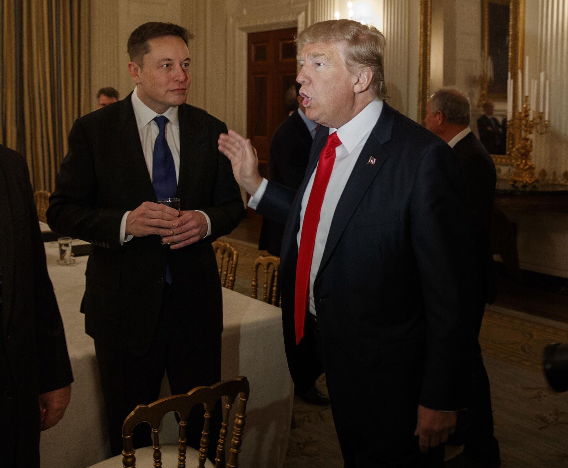 President Donald Trump talks with Tesla and SpaceX CEO Elon Musk, center, and White House chief strategist Steve Bannon during a meeting with business leaders in the State Dining Room of the White House in Washington, Friday, Feb. 3, 2017 - Sputnik International, 1920, 29.12.2022