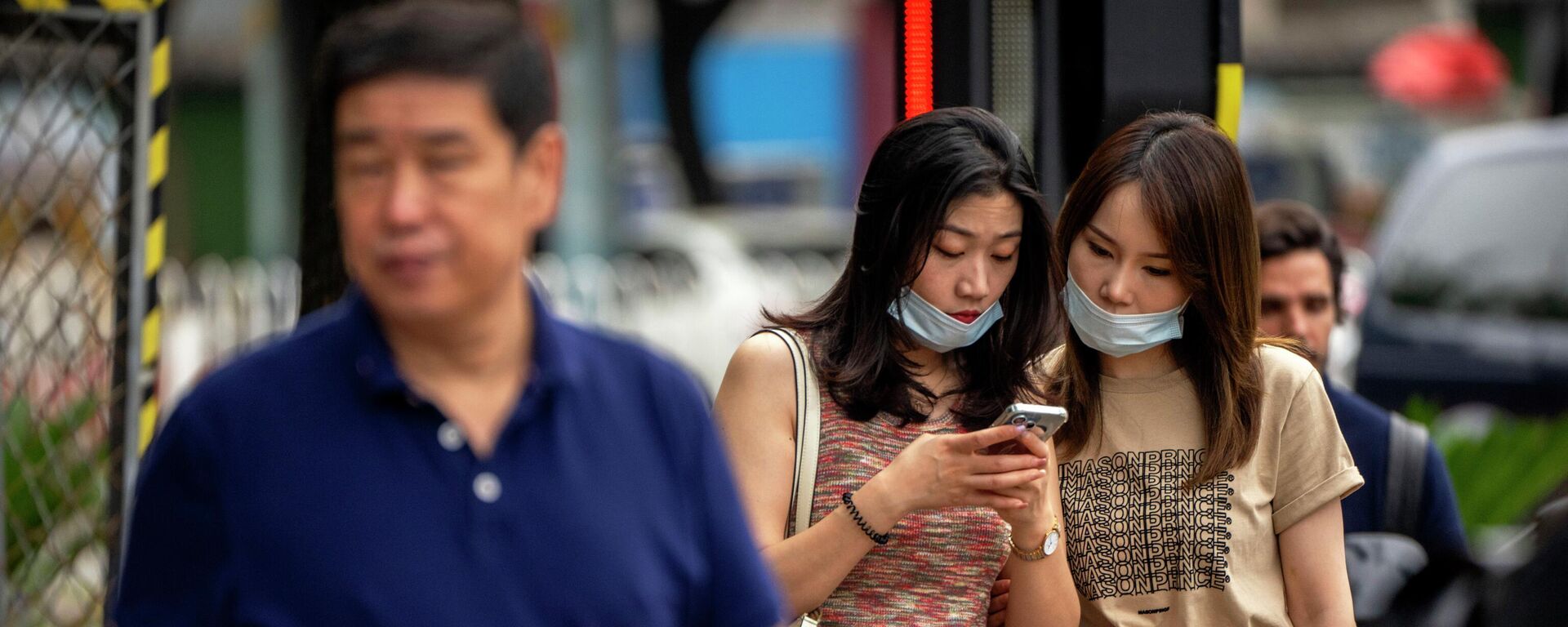Women wearing face masks look at a smartphone as they stand on a street corner in Beijing, Wednesday, July 6, 2022 - Sputnik International, 1920, 17.01.2023