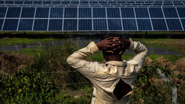 52-year old farmer Sitaram Murmu, whose agriculture land had been transfered to build a solar power plant stands near the plant in Mikir Bamuni village, Nagaon district, northeastern Assam state, India, Feb. 18, 2022. - Sputnik International