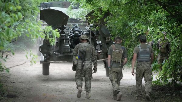 Ukrainian soldiers move a U.S.-supplied M777 howitzer into position to fire at Russian positions in Ukraine's eastern Donbas region Saturday, June 18, 2022 - Sputnik International