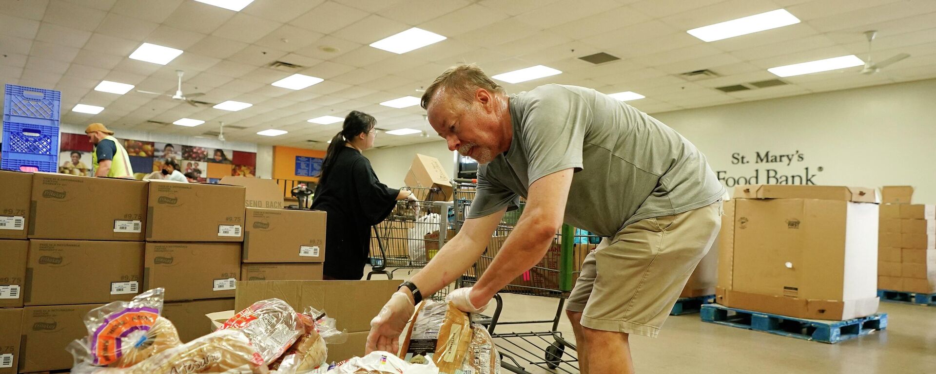 Volunteers fill up grocery carts with food for distribution into drive through vehicles at the St. Mary's Food Bank Wednesday, June 29, 2022, in Phoenix - Sputnik International, 1920, 21.11.2023