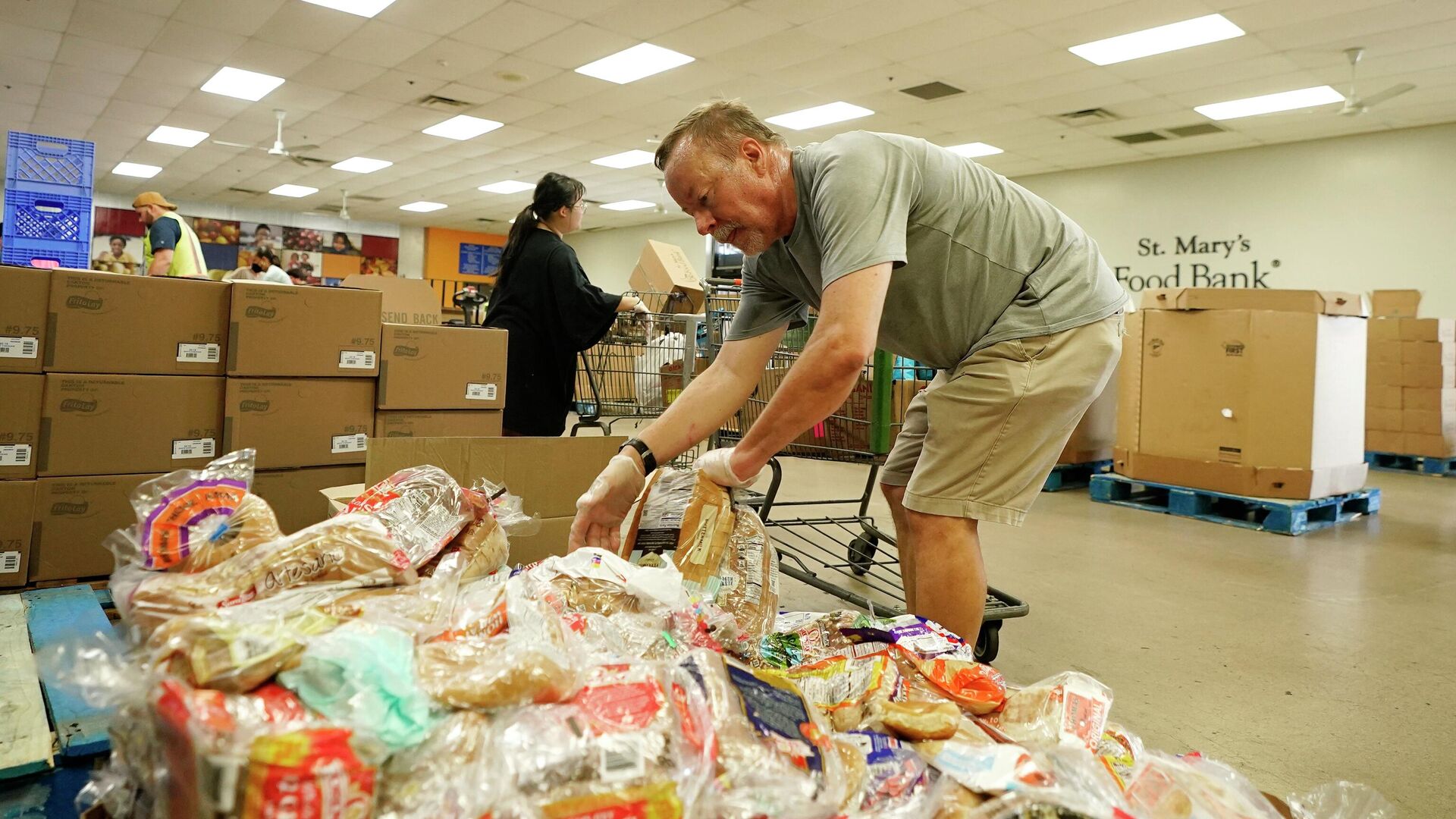 Volunteers fill up grocery carts with food for distribution into drive through vehicles at the St. Mary's Food Bank Wednesday, June 29, 2022, in Phoenix - Sputnik International, 1920, 26.07.2022
