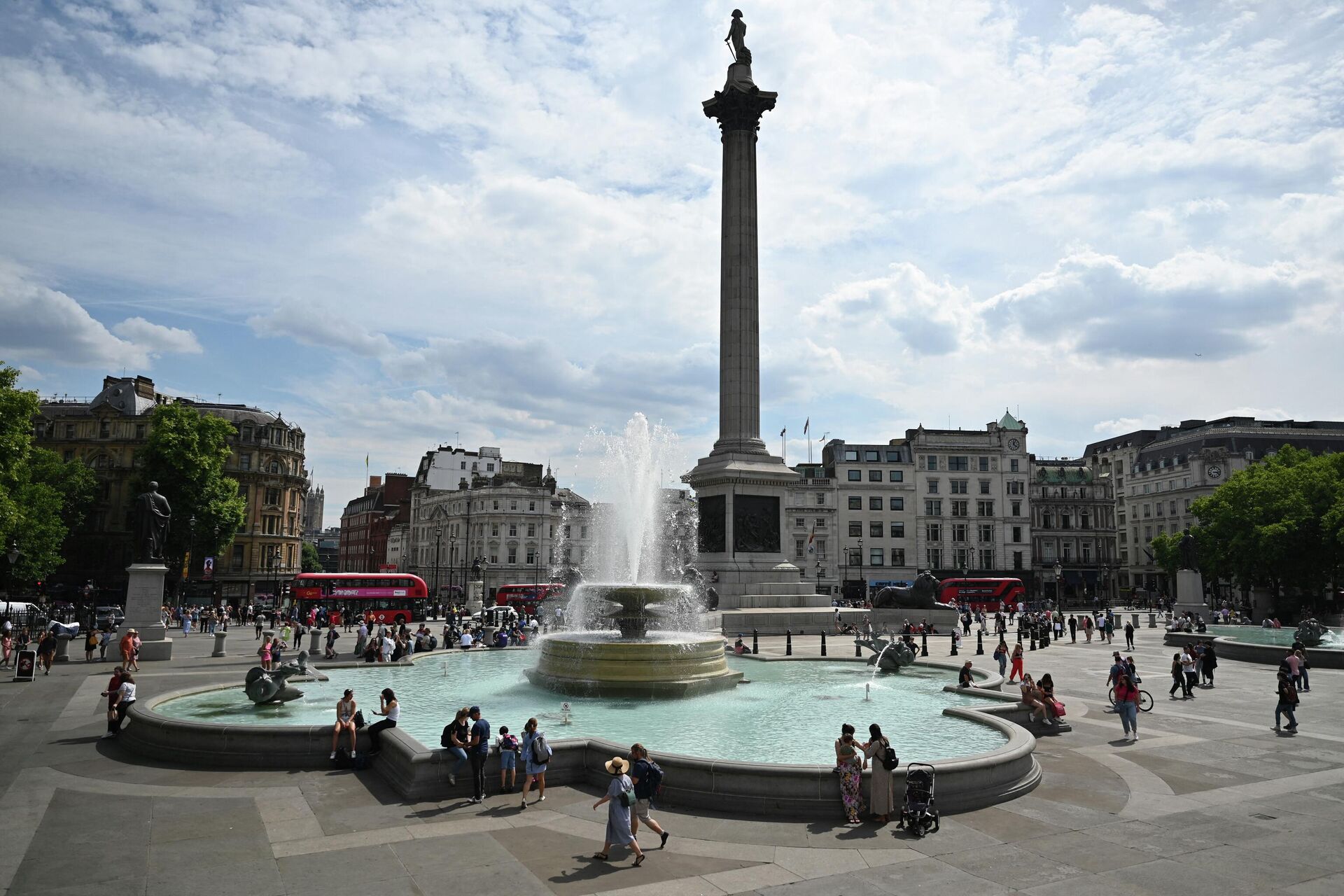 Pedestrians cool off with their feet in the water of the Trafalgar Square fountain, in central London, on July 13, 2022, during a heatwave. - Britain issued, on July 13, 2022 an extreme heat warning, with temperatures predicted to hit more than 30 degrees Celsius (86 Fahrenheit) across large parts of England and Wales - Sputnik International, 1920, 18.07.2022