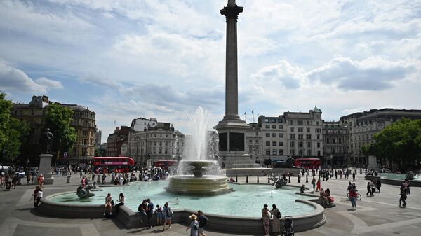 Pedestrians cool off with their feet in the water of the Trafalgar Square fountain, in central London, on July 13, 2022, during a heatwave. - Britain issued, on July 13, 2022 an extreme heat warning, with temperatures predicted to hit more than 30 degrees Celsius (86 Fahrenheit) across large parts of England and Wales - Sputnik International