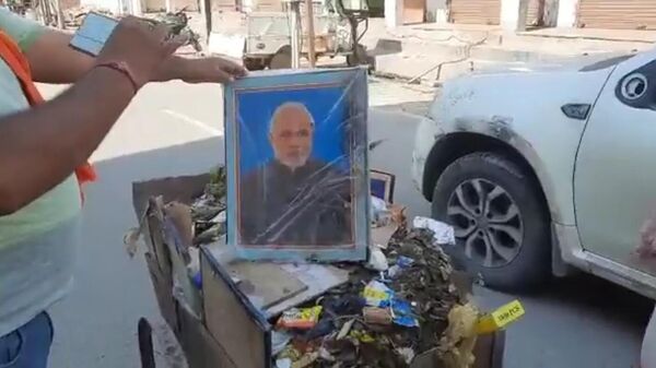 A contractual worker at UP's Mathura Nagar Nigam was terminated after he was found carrying pictures of PM Narendra Modi and CM Yogi Adityanath among other dignitaries in his hand held garbage cart - Sputnik International