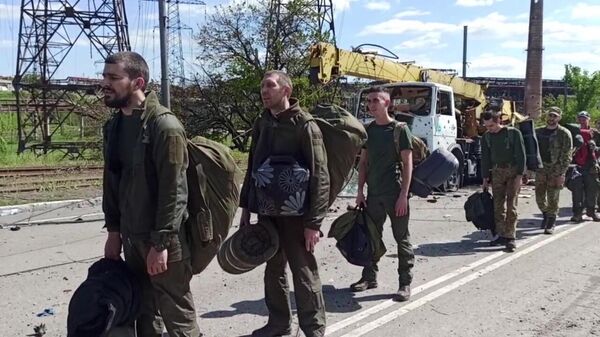 In this handout video grab released by the Russian Defence Ministry, Ukrainian soldiers of the Azov battalion who have surrendered at the Azovstal steel plant walk on a road in the Russia-controlled port city of Mariupol, Donetsk People's Republic - Sputnik International