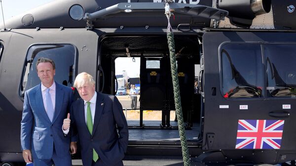 Britain's Prime Minister Boris Johnson gestures in front of an helicopter as he visits the Farnborough Airshow, in Farnborough, on July 18, 2022. - Sputnik International