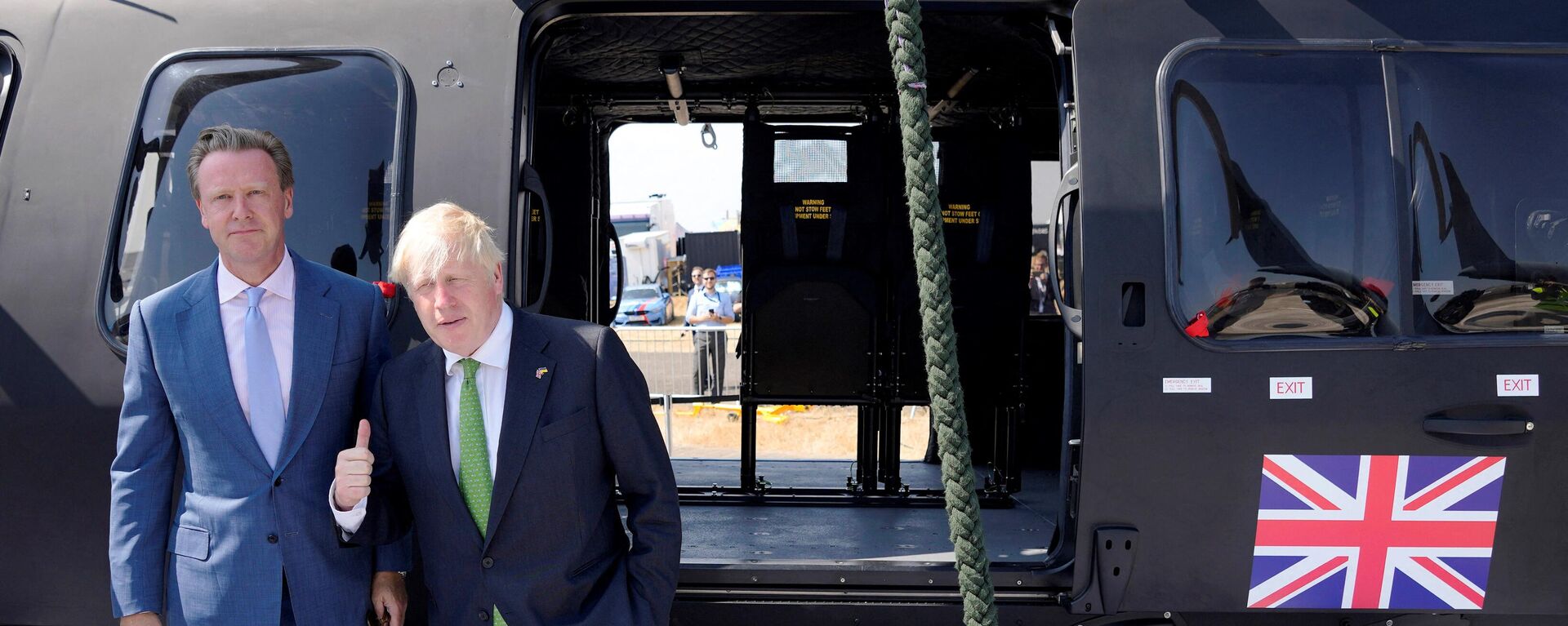Britain's Prime Minister Boris Johnson gestures in front of an helicopter as he visits the Farnborough Airshow, in Farnborough, on July 18, 2022. - Sputnik International, 1920, 18.07.2022
