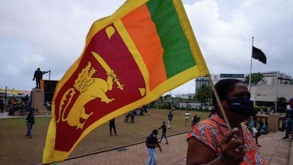 A protestor holds Sri Lankan flag outside president's office in Colombo, Sri Lanka, Wednesday, July 20, 2022. - Sputnik International