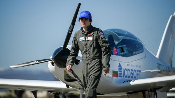 Mack Rutherford, 16, walks in front of his airplane, prior to his departure on a bid to become the youngest solo pilot to fly around the world at Sofia West airport near Radomir on March 23, 2022.  - Sputnik International