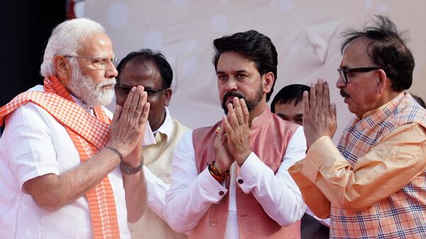 Indian Minister for Heavy Industries Mahendra Nath Pandey, right, and Information and Broadcasting Minister Anurag Thakur greet Indian Prime Minister Narendra Modi during the oath-taking ceremony of Yogi Adityanath as Chief Minister of Uttar Pradesh state in Lucknow, India, Friday, March 25, 2022. - Sputnik International
