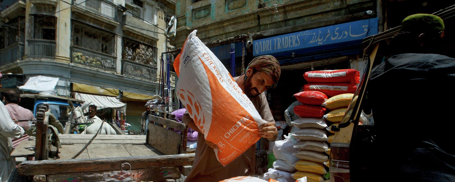 A laborer unload sacks of chickpeas at a market in Karachi, Pakistan, Thursday, July 14, 2022. - Sputnik International, 1920, 20.09.2022