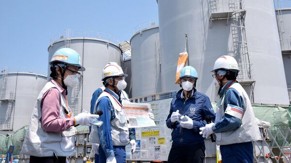 Director General of the International Atomic Energy Agency (IAEA) Rafael Grossi (2nd-R) stands in front of the storage tanks for radioactive water as he visits the Tokyo Electric Power Company Holdings (TEPCO) Fukushima Daiichi nuclear power plant in Okuma, Fukushima prefecture on May 19, 2022. - Sputnik International