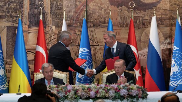 Turkish President Recep Tayyip Erdogan, right, and U.N. Secretary General, Antonio Guterres, sit as two representatives of Ukraine and Russia delegations check hands during a signing ceremony at Dolmabahce Palace in Istanbul, Turkey, Friday, July 22, 2022 - Sputnik International