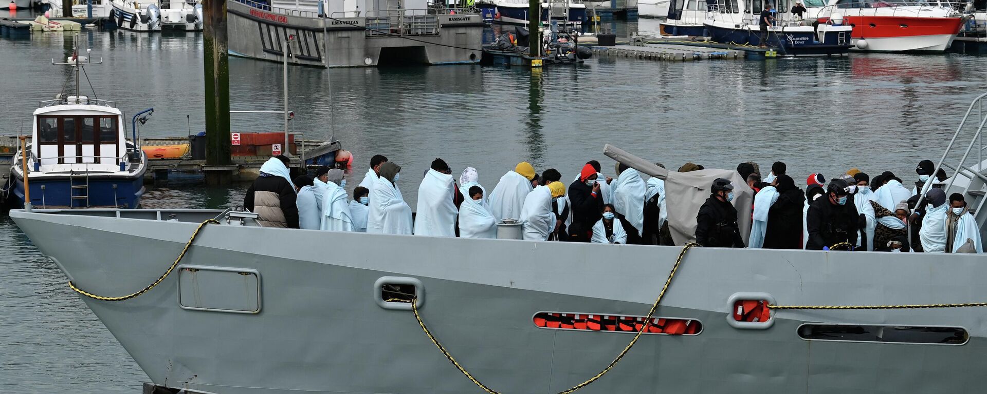 Migrants huddle together under blankets, brought to port by the UK Border Force after being picked up crossing the English Channel from France on April 14, 2022 - Sputnik International, 1920, 16.08.2022