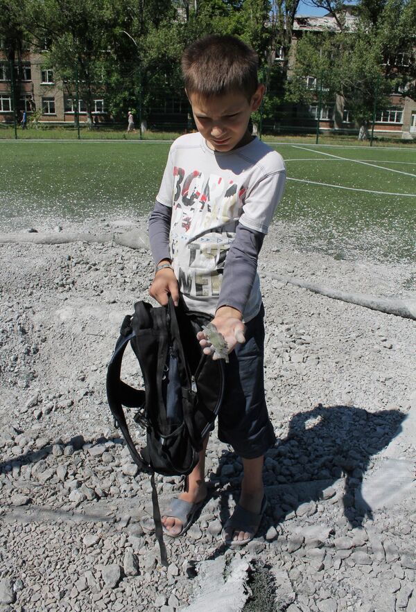 A young resident of Gorlovka shows a piece of ammunition that exploded in a local school. On August 25, 2015, the Ukrainian military shelled the city, damaging two schools, a kindergarten, and a vocational school building. Four local residents were wounded and one woman was killed. - Sputnik International