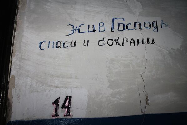 An inscription reading &quot;God save us&quot; above one of the apartments in a house destroyed by Ukrainian shelling. Donetsk, 2015. - Sputnik International