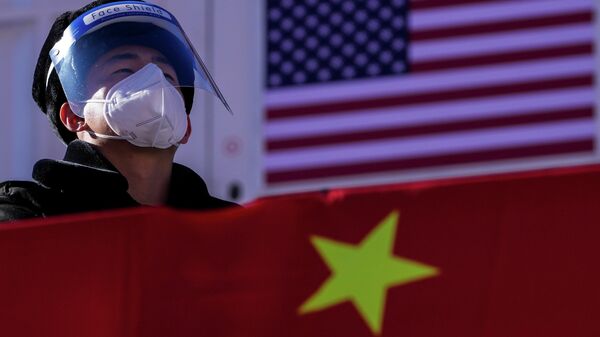 A security personnel wearing a face shield and a mask to help protect from the coronavirus stands watch at the Alpine downhill venue displaying the China and United States national flags - Sputnik International
