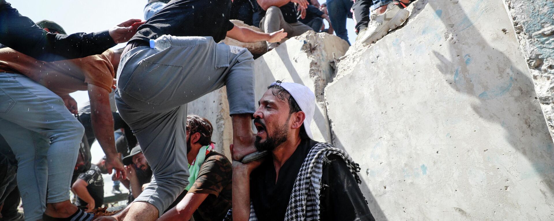 Supporters of the Iraqi cleric Moqtada Sadr climb over concrete barriers along the Al-Jumhuriya (Republic) bridge that leads to the capital Baghdad's high-security Green Zone, as they protest against a rival bloc's nomination for prime minister, on July 30, 2022 - Sputnik International, 1920, 30.07.2022