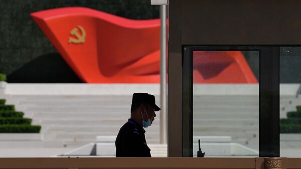A security guard stands near a sculpture of the Chinese Communist Party flag at the Museum of the Communist Party of China on May 26, 2022, in Beijing. - Sputnik International