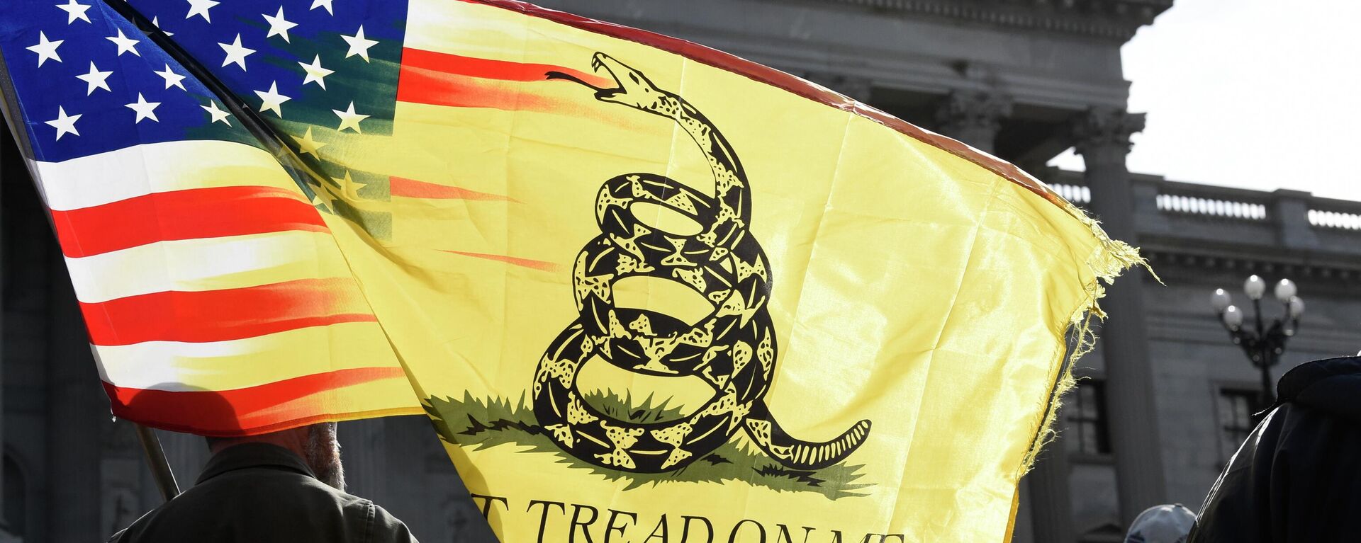 A man holds a flag and listens to a speaker during a rally at South Carolina's Statehouse on Sunday, Jan. 17, 2021, in Columbia, S.C. - Sputnik International, 1920, 03.08.2022