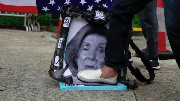 Pro-China supporters step on a picture of U.S. House Speaker Nancy Pelosi during a protest outside the Consulate General of the United States in Hong Kong, Wednesday, Aug. 3, 2022. U.S. House Speaker Nancy Pelosi arrived in Taiwan late Tuesday, becoming the highest-ranking American official in 25 years to visit the self-ruled island claimed by China, which quickly announced that it would conduct military maneuvers in retaliation for her presence. (AP Photo/Kin Cheung) - Sputnik International