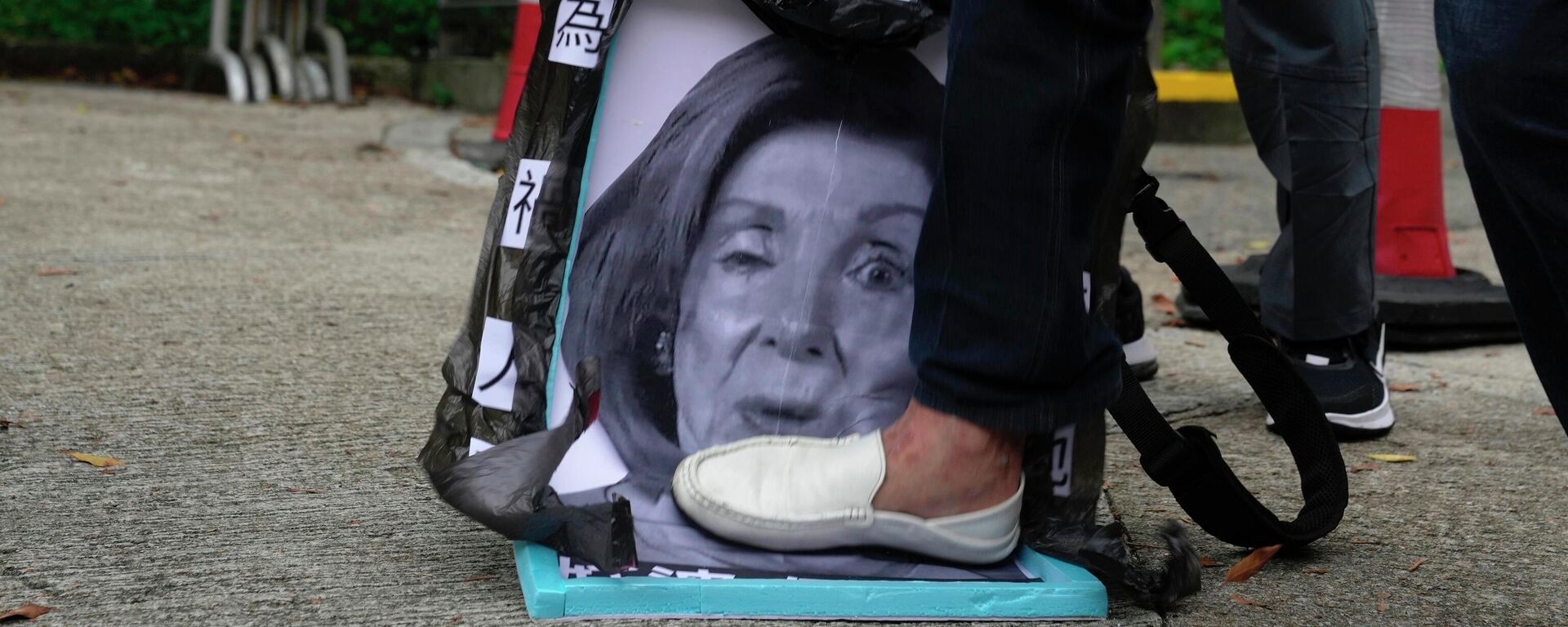 Pro-China supporters step on a picture of U.S. House Speaker Nancy Pelosi during a protest outside the Consulate General of the United States in Hong Kong, Wednesday, Aug. 3, 2022. U.S. House Speaker Nancy Pelosi arrived in Taiwan late Tuesday, becoming the highest-ranking American official in 25 years to visit the self-ruled island claimed by China, which quickly announced that it would conduct military maneuvers in retaliation for her presence. (AP Photo/Kin Cheung) - Sputnik International, 1920, 23.01.2023