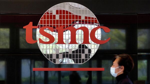 A man walks past a company logo at the headquarters of the world's largest semiconductor maker TSMC in Hsinchu on January 29, 2021 - Sputnik International