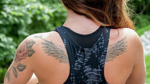 Woman with brown hair and back tattoos  - Sputnik International