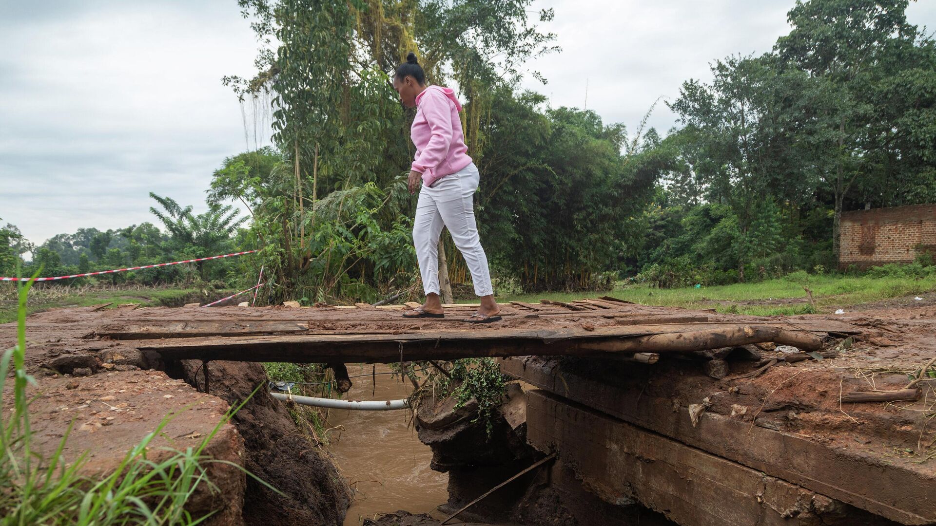 A woman walks on a makeshift bridge after the bridge was destroyed by floods in Busamaga, near Mbale, eastern Uganda, on August 2, 2022. - Sputnik International, 1920, 05.08.2022