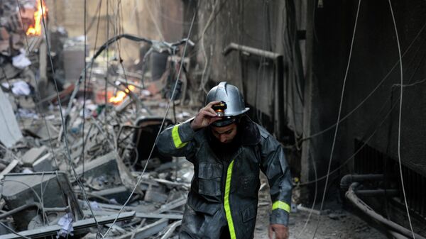 A Palestinian firefighter fights the blaze amid the destruction following an Israeli air strike on Gaza City, on August 5, 2022. - Sputnik International