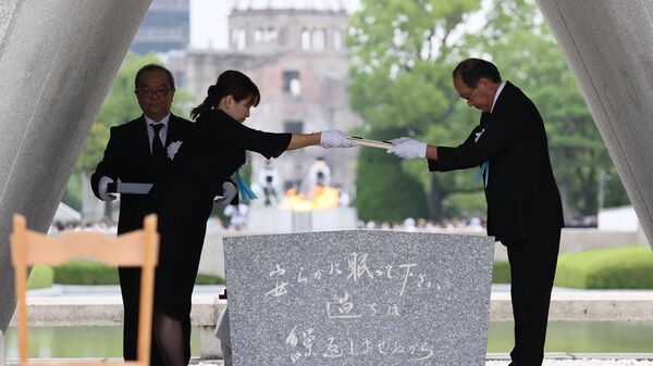 Hiroshima Mayor Kazumi Matsui (R) and representatives of the bereaved families enshrine the list of the atomic bomb victims at the Cenotaph during the annual memorial ceremony at the Hiroshima Peace Memorial Park in Hiroshima on August 6, 2022, to mark 77 years since the world's first atomic bomb attack. - Sputnik International