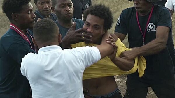 This screen grab made from a video taken and released by Mannar Levo shows security officials restraining a man (yellow shirt) who attacked a Japanese sailor with scissors during a World War II memorial ceremony to mark the 80th anniversary of the Battle of Guadalcanal, in Honiara on the Solomon Islands on August 8, 2022.  - Sputnik International