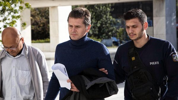 Alexander Vinnik (C), who headed BTC-e, an exchange he operated for the cyber currency, is escorted by police after Greece's Supreme Court has ruled on December 13, 2017 in favor of extraditing the Russian suspect to the United States to stand trial for allegedly laundering billions of dollars using the virtual currency bitcoin - Sputnik International