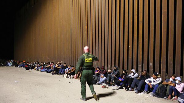 A U.S. Border Patrol agent monitors immigrants after they crossed the border with Mexico on May 18, 2022 in Yuma, Arizona - Sputnik International