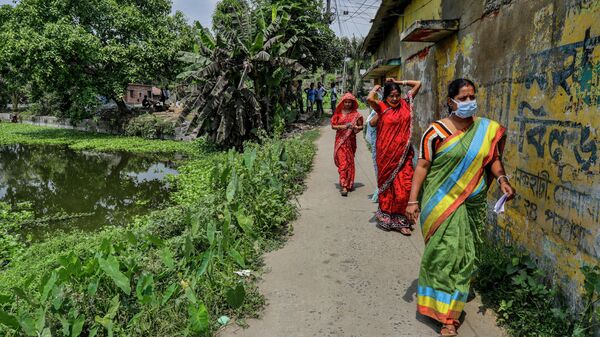 Voters walk through a village street to cast their votes at a polling station during third phase of West Bengal state elections in Baruipur, South 24 Pargana district, India, Tuesday, April 6, 2021.  - Sputnik International