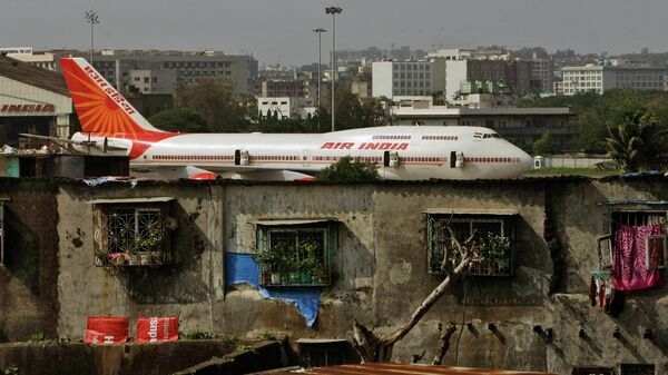 In this May 25, 2010 file photo, an Air India plane is seen in the background of slums adjoining the the international airport in Mumbai, India. Personal data of an unspecified number of travelers has been comprised in a hack of a company that manages customer data including credit cards, passports and phone numbers for India’s national carrier. - Sputnik International