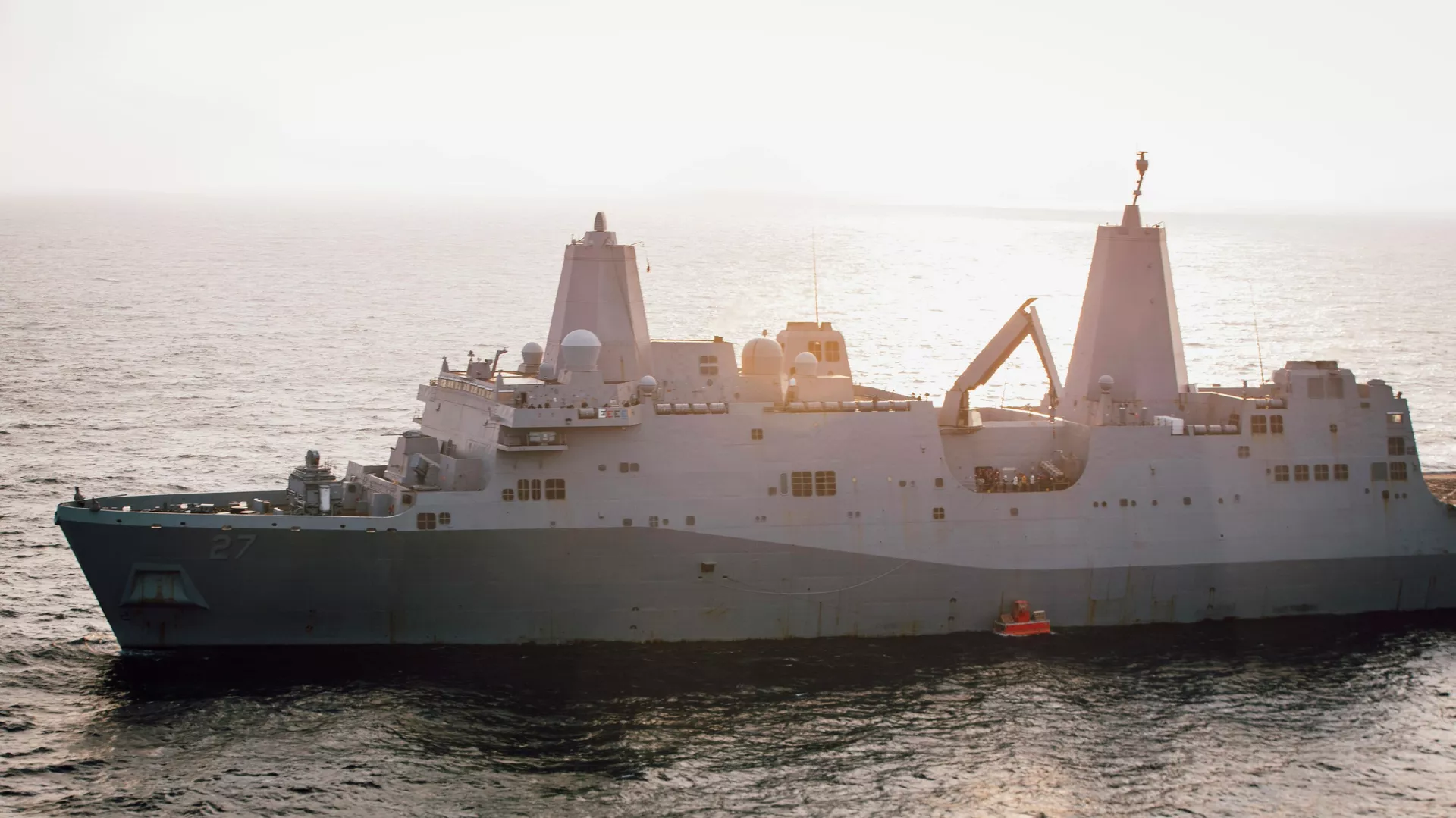 In this handout photo from the U.S. Marine Corps, the USS Portland lowers a floating target into the water that it will later fire on with a laser weapon system, in the Gulf of Aden, Tuesday, Dec. 14, 2021. The U.S. Navy announced Wednesday it tested a laser weapon and destroyed a floating target in the Mideast, a system that could be used to counter bomb-laden drone boats deployed by Yemen's Houthi rebels in the Red Sea. (Staff Sgt. Donald Holbert/U.S. Marine Corps via AP) - Sputnik International, 1920, 11.12.2024