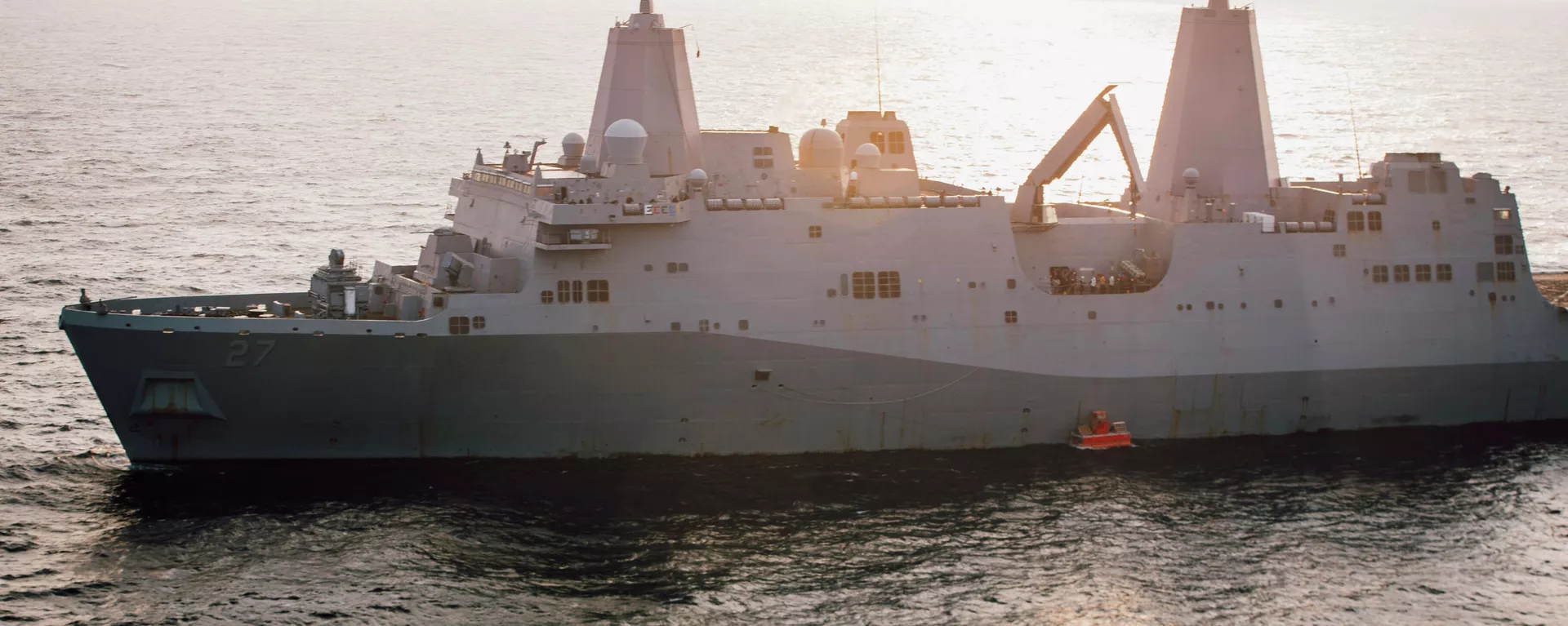 In this handout photo from the U.S. Marine Corps, the USS Portland lowers a floating target into the water that it will later fire on with a laser weapon system, in the Gulf of Aden, Tuesday, Dec. 14, 2021. The U.S. Navy announced Wednesday it tested a laser weapon and destroyed a floating target in the Mideast, a system that could be used to counter bomb-laden drone boats deployed by Yemen's Houthi rebels in the Red Sea. (Staff Sgt. Donald Holbert/U.S. Marine Corps via AP) - Sputnik International, 1920, 11.12.2024